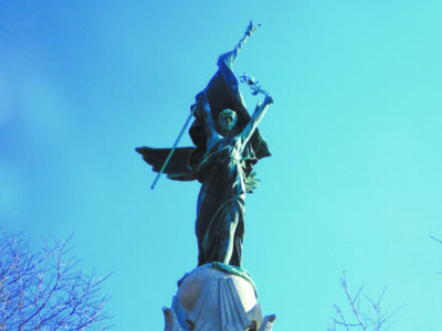 statue of woman in toga holding up flag