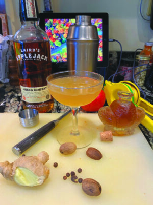 cocktail in martini glass surrounded by ingredients