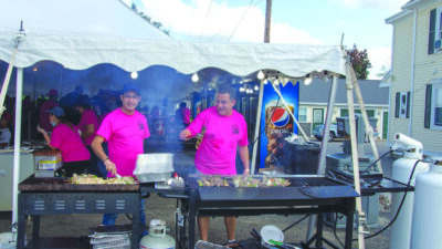 men cooking outside of event tent at food festival