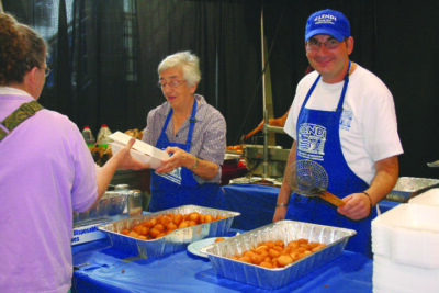 volunteers serving food behind table at Glendi celebration