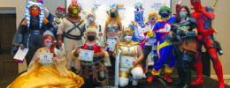group of people in cosplay posing with their contest winner award certificates