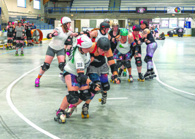 women playing roller derby on indoor rink