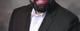 studio portrait of bearded man wearing suit jacket