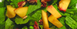 cut peaches and pecans on arugula