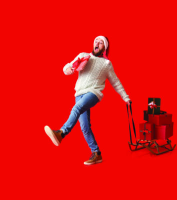 Walking man with heap of Christmas gifts on sledges against red background with space for text