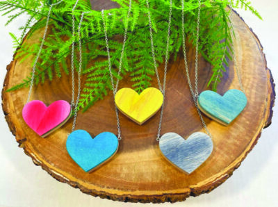 heart shaped wooden pendants displayed on wooden circle with fern