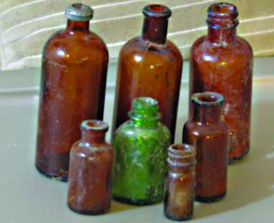 assortment of large and small brown and green old glass bottles