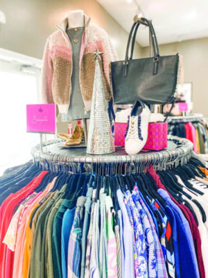 circular shirt display rack in store, display of shoes, handbag and jacket on top