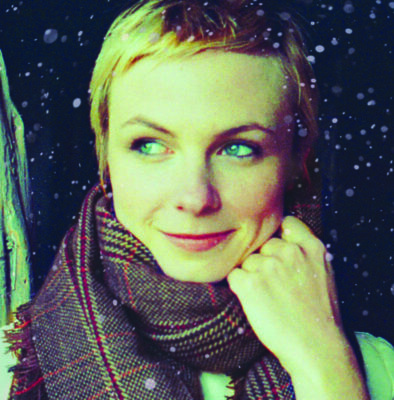 woman wearing scarf, looking to the side, snow falling