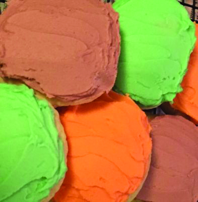 close up of round sugar cookies covered in different colors of frosting