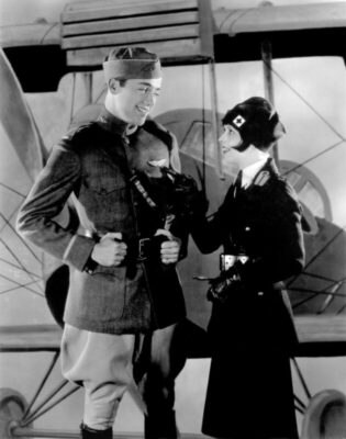old film still of male and female actress dressed in old fashioned military uniforms