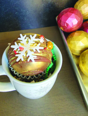 golden cocoa bomb with sugar snowflake on top, sitting in mug on table