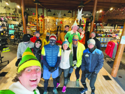 group of people standing in sports shop, posing in their running gear