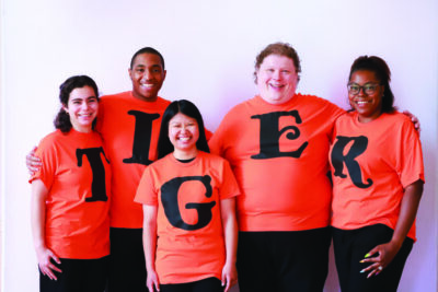 5 young performers wearing shirts with letters spelling out tiger