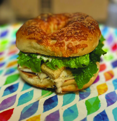 a bagel sandwich with lettuce, croutons, cheese