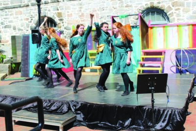 5 Irish Dancers in green dresses, dancing on temporary stage outdoors