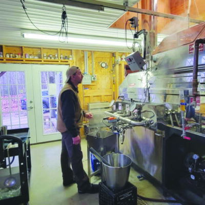 man distilling maple syrup at farm
