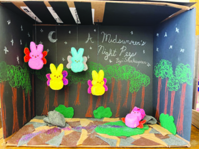 diaroma of peep candies in scene from midsummer night's dream, four bunny peeps with wings hanging from top of cardboard box, one peep sleeping in grass below, stars in background