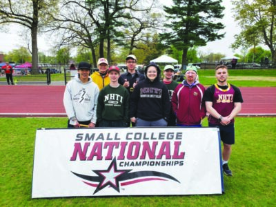 young women and men standing behind large banner with words small college national championships on grassy sportsfield