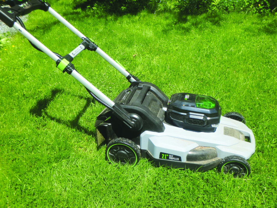electric lawn mower on green grassy lawn