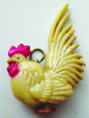 small plastic charm shaped like chicken with loop on the back