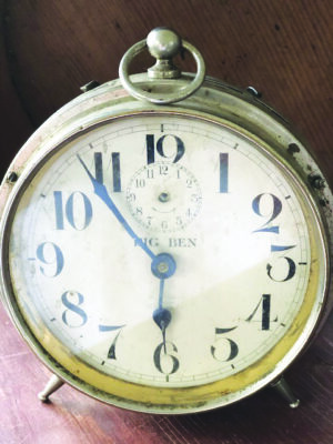 small round standing alarm clock with metal casing, decorative face