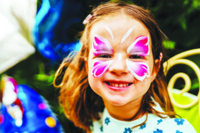 Cute little girl having her face painted for kids party. carnival family lifestyle Face painting, headshot close up
