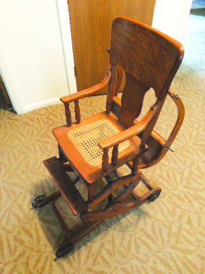 antique wooden chair viewed from slightly above, woven cane seat, wooden armrests, mechanics under the seat for raising or lowering the chair, on wheels