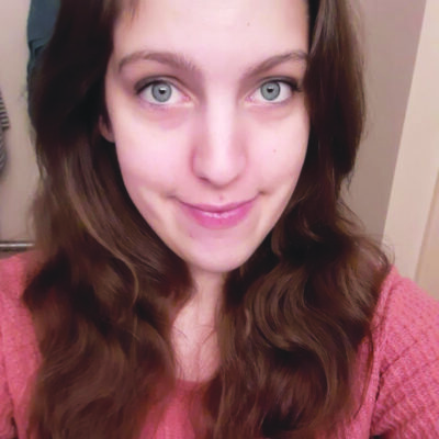 selfie of woman with long hair and large eyes, smiling