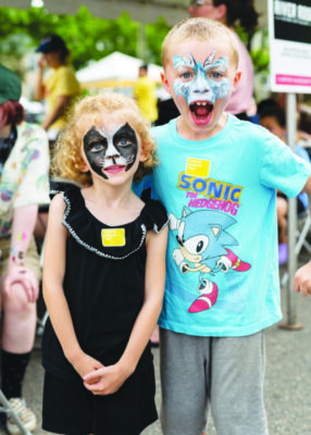 a girl and boy child posing with painted faces