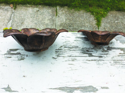 flower shaped metal bowl things sitting on old table outside