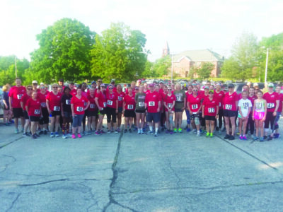 Group photo of racers in matching red t-shirts with race numbers