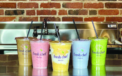 Multiple colorful smoothies on a juice bar counter at Fresh Chef Press in Manchester, NH