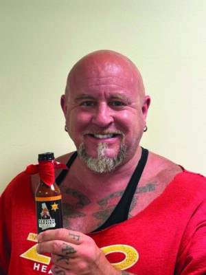 Picture of Ed Barooney holding his product, Dandido Hot Sauce.