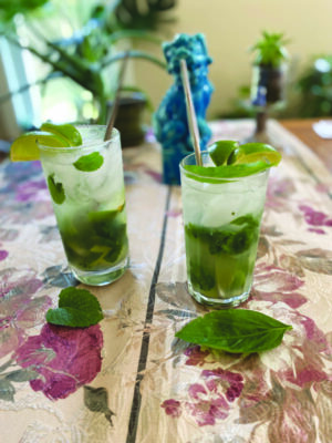 2 tall glasses, cocktails with mint leaves
