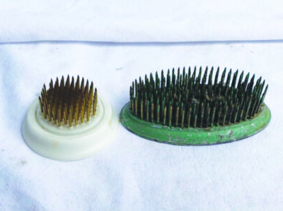 a round and a oval base with nail-like spikes poking out of top