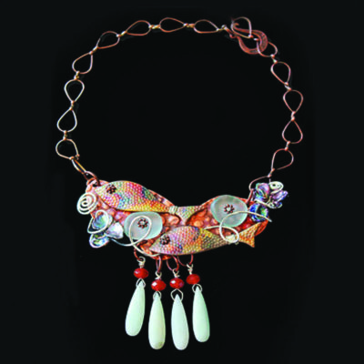 intricate, colorful metal necklace showing abstract fish and four hanging beads