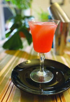 cocktail glass on small plate, brightly colored cocktail