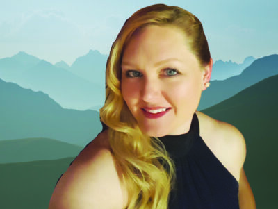 headshot of long haired woman with hair draped over one shoulder, cut out and photoshopped into mountain background