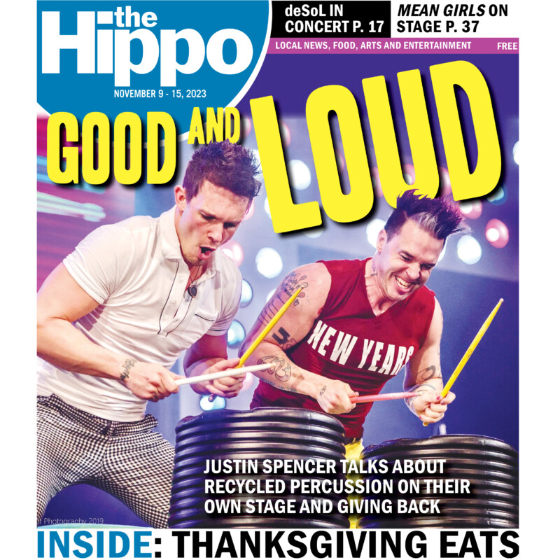 frontcover of Hippo showing 2 men drumming waist height barrels on stage with bright lights behind, text above their heads reads good and loud