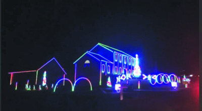 House, garage and yard decoraded with christmas lights of different colors