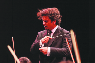 male conductor leading musicians in preformance