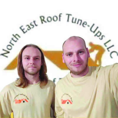 long-haired man and balding man wearing shirts with company logo in front of logo in background