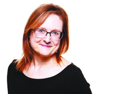red haired woman wearing glasses, closed mouth smile, headshot on white background