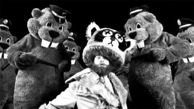 Man surrounded by large beavers in a black and white film setting