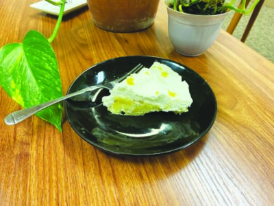 slice of lemon cream pie with fork on plate on table