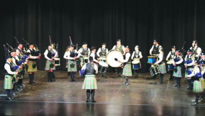 Scottish band playing on stage wearing kilts