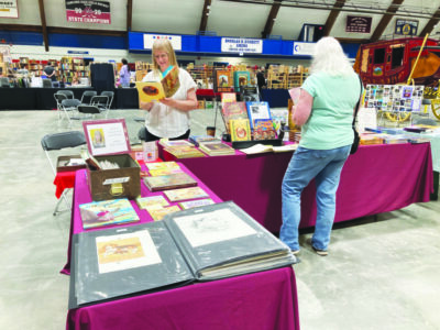 tables displaying books at book fair, people browsing at the tables