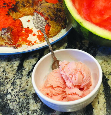 bowl of pink sherbert sitting beside hunk of watermelon and plate of ring cake