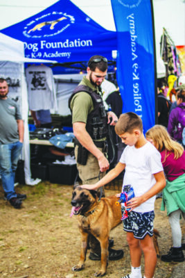 police officer with dog at event, kids petting dog